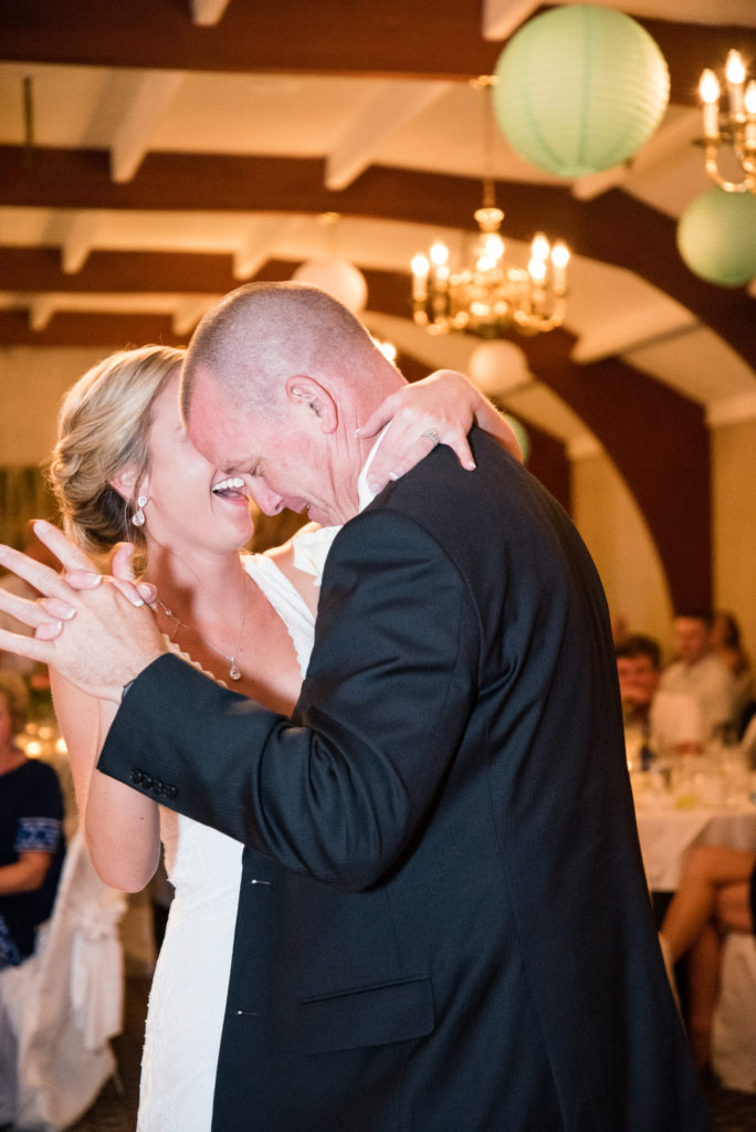 bride laughing while dancing with her dad