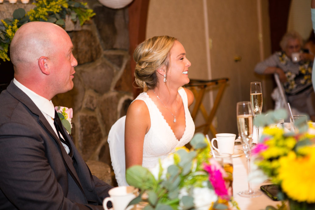 Bride and groom smiling during toasts
