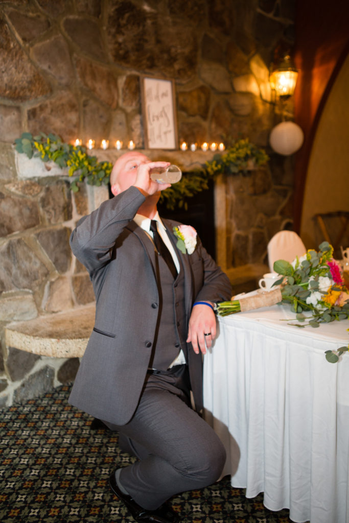 groom on one knee chugging a drink