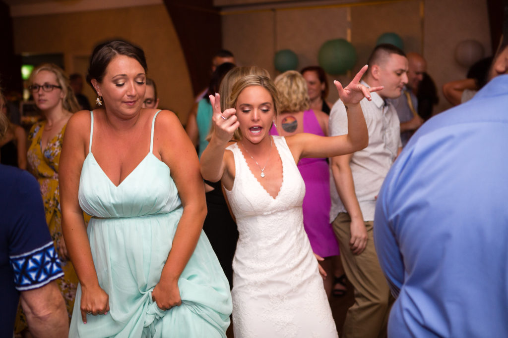 bride with her bridesmaid on the dance floor having fun