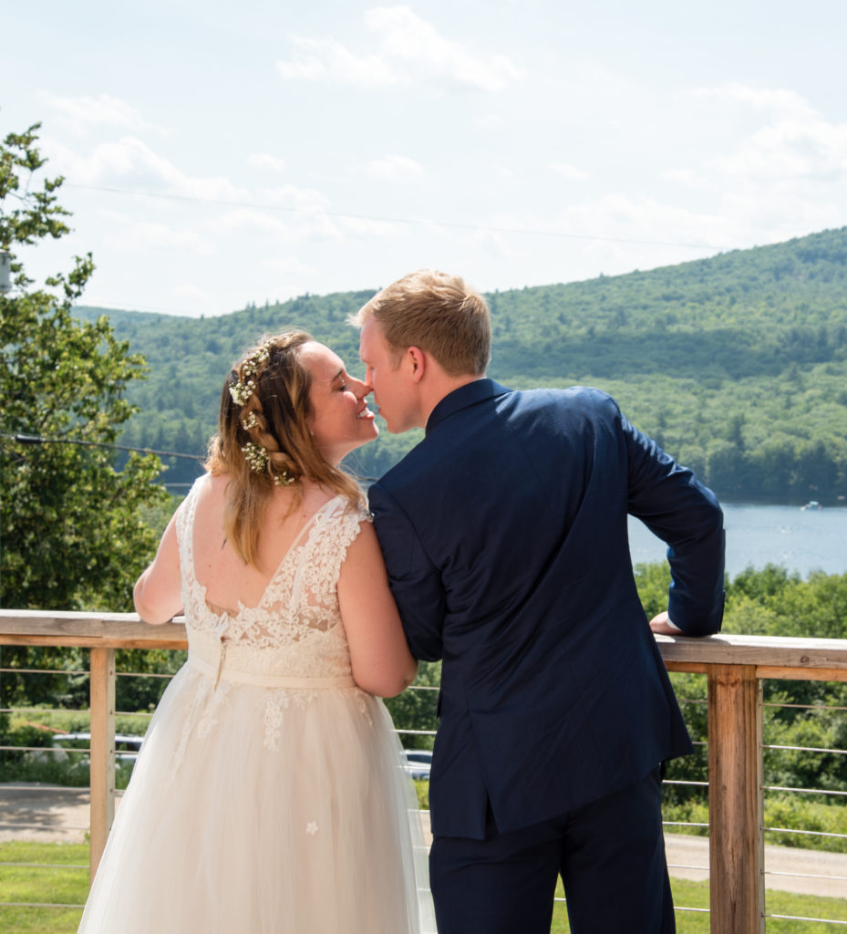 bride and groom kissing in front of the lake 
