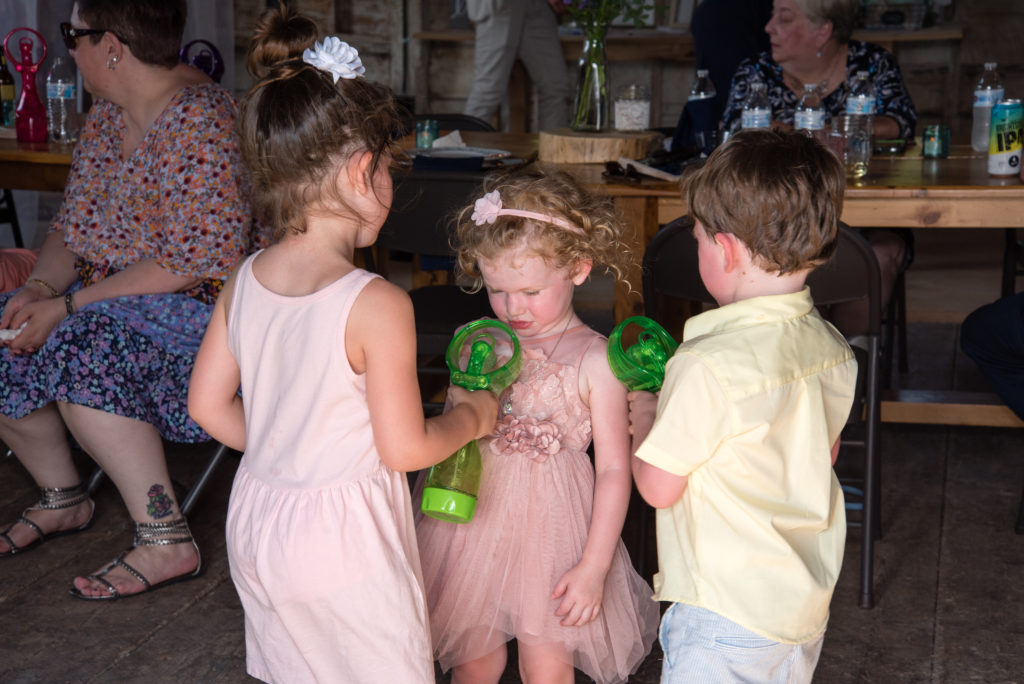 kids playing with water fans on a hot wedding day