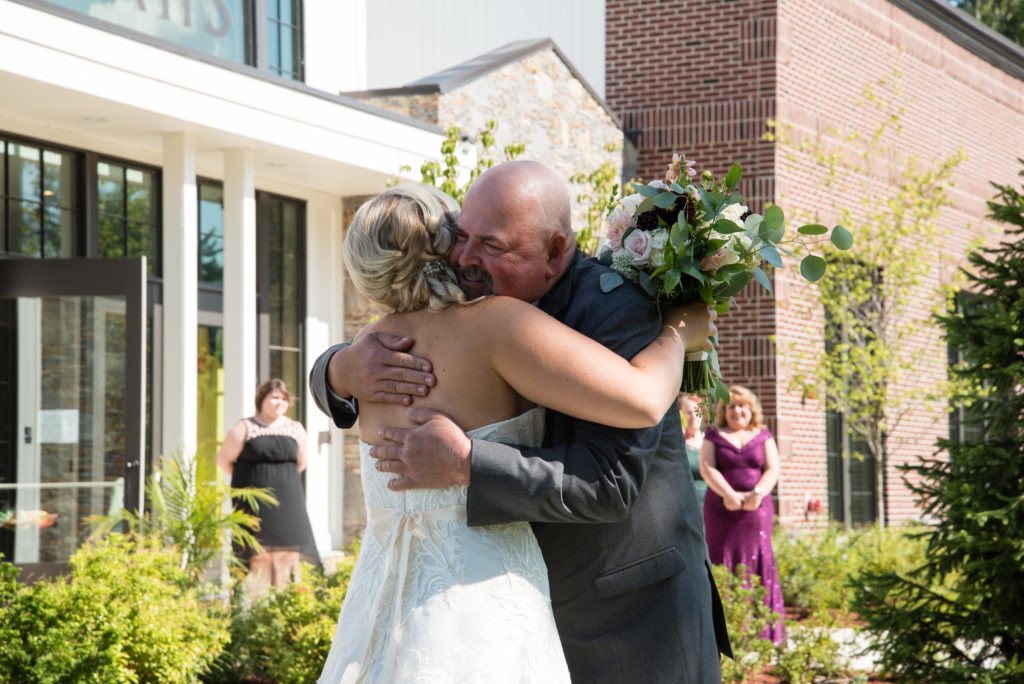 father and bride hugging