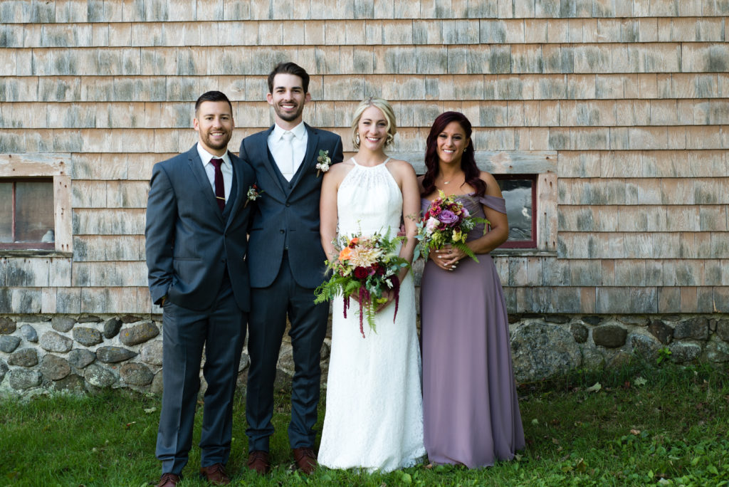 bridal party in front of a barn