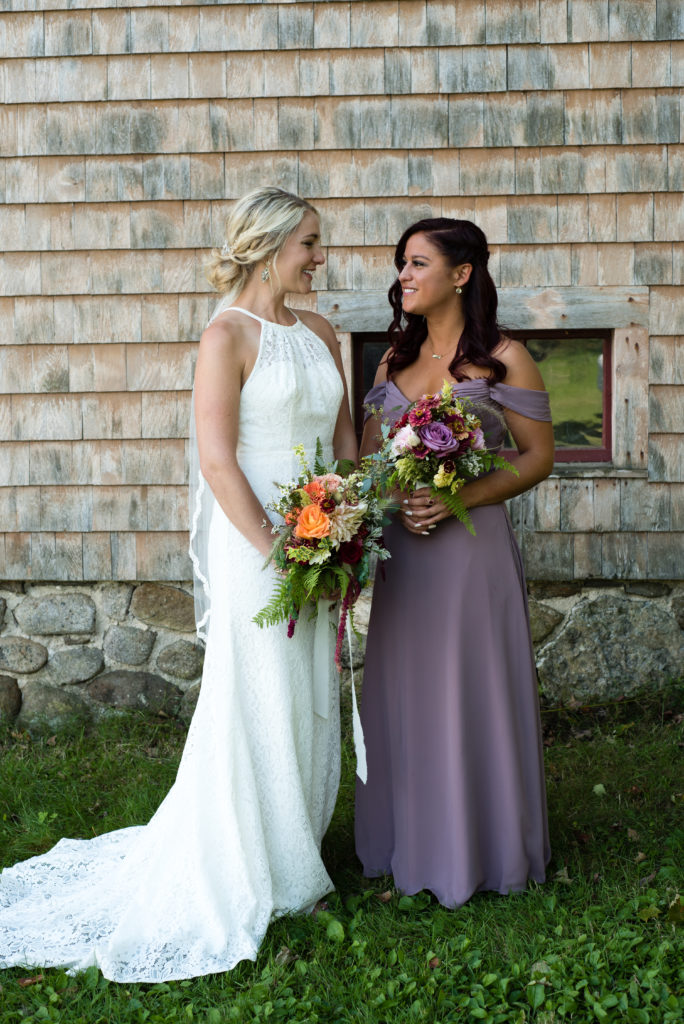 bride and her maid of honor looking at each other smiling
