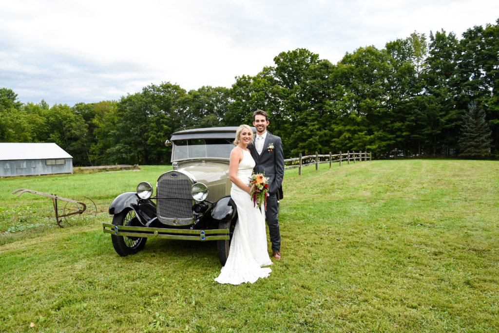 bride and groom in front of antique car