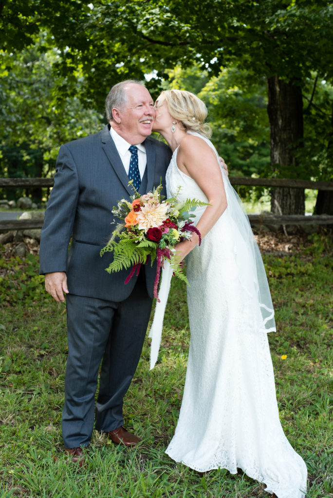 bride kissing her father on the cheek, dad smiling