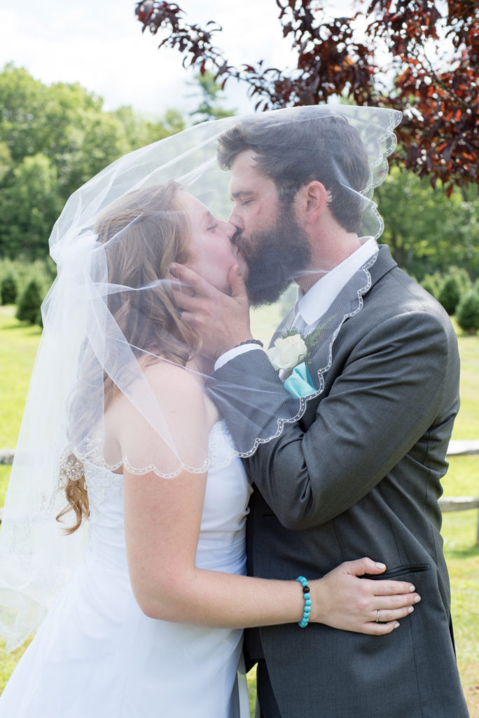 bride and groom kissing under veil