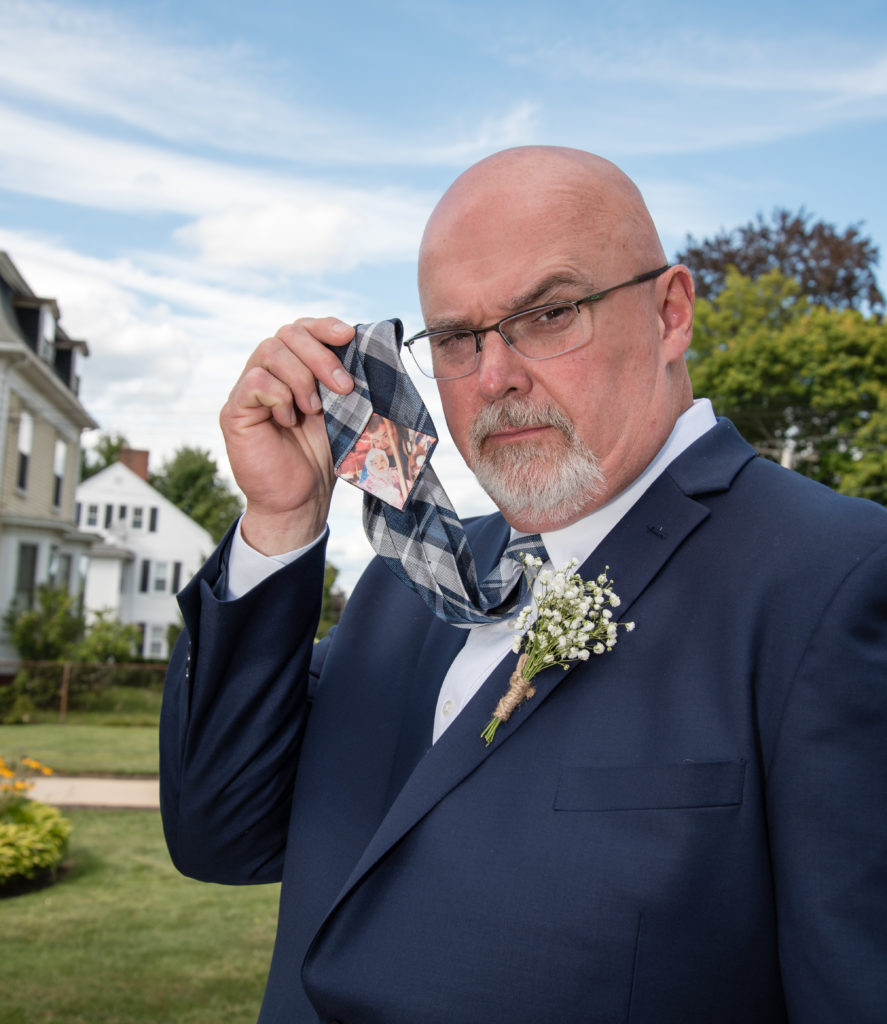Bride's dad holding up his tie with a picture of bride and dad on it 