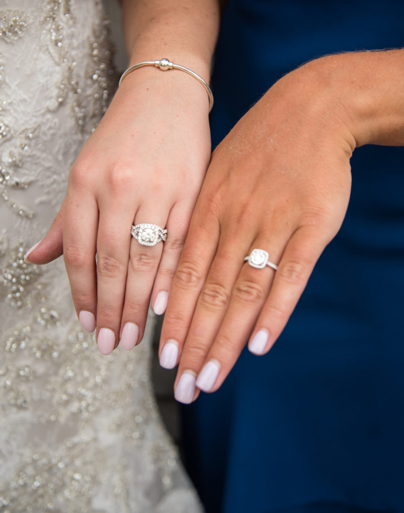 bride with her friend showing off engagement rings
