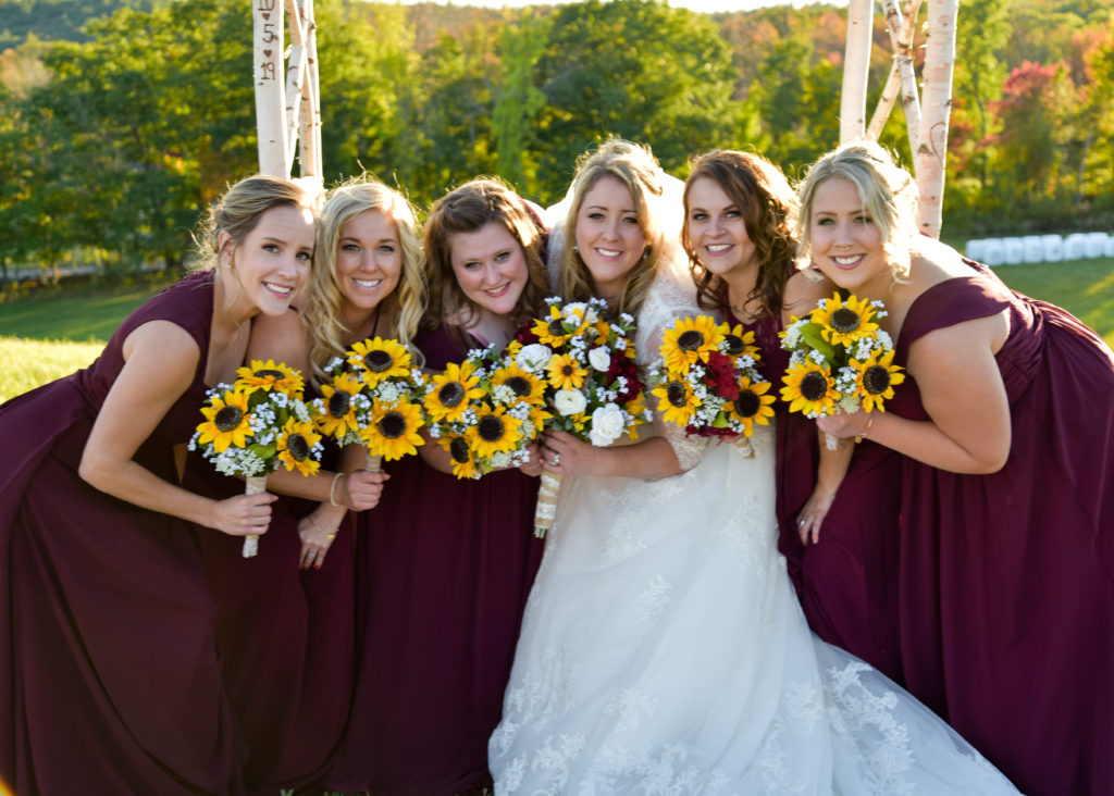 bride and bridesmaids huddling with flowers