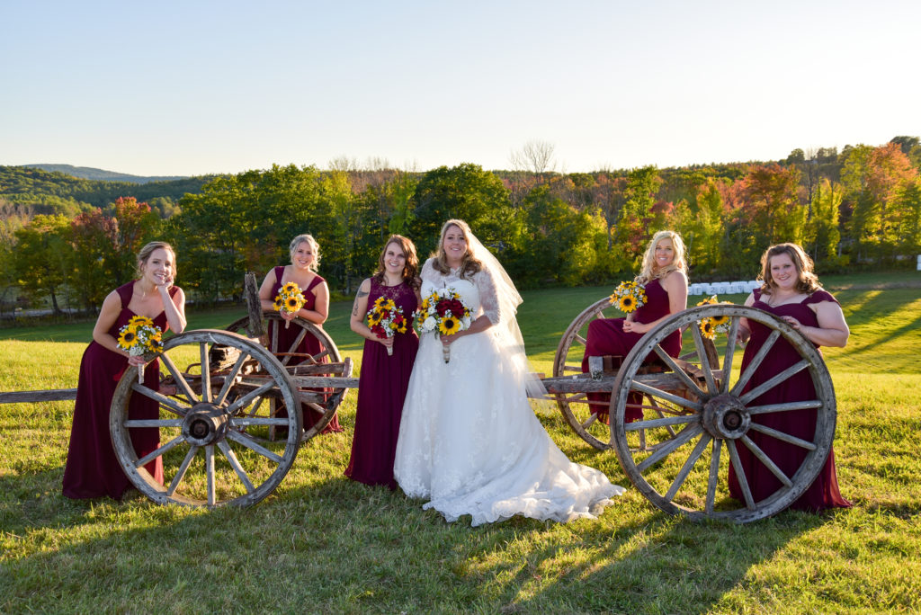 bride and her girls posing with an old wagon 