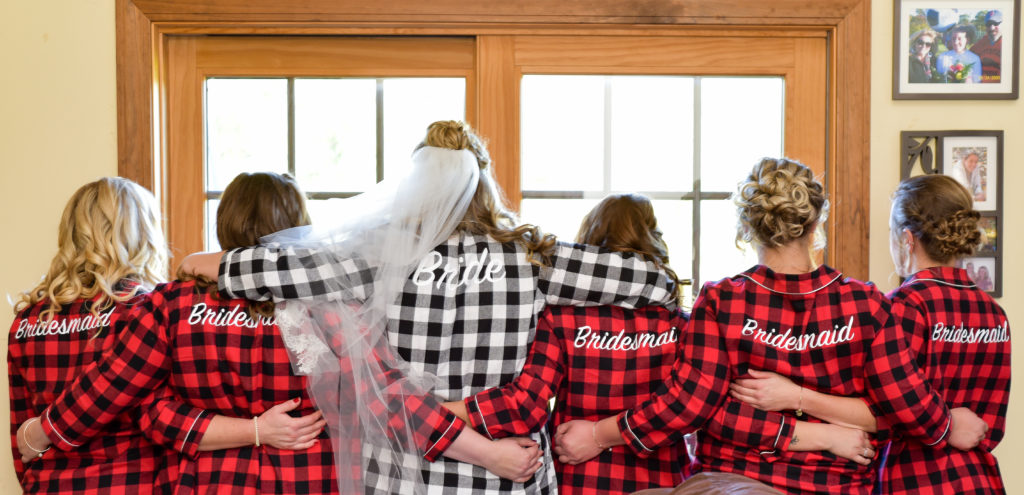 bride with her bridesmaids in matching plaid shirts 