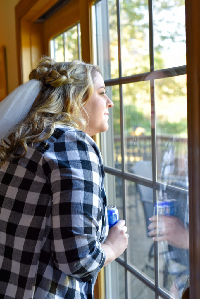 bride peaking out window at guests arriving