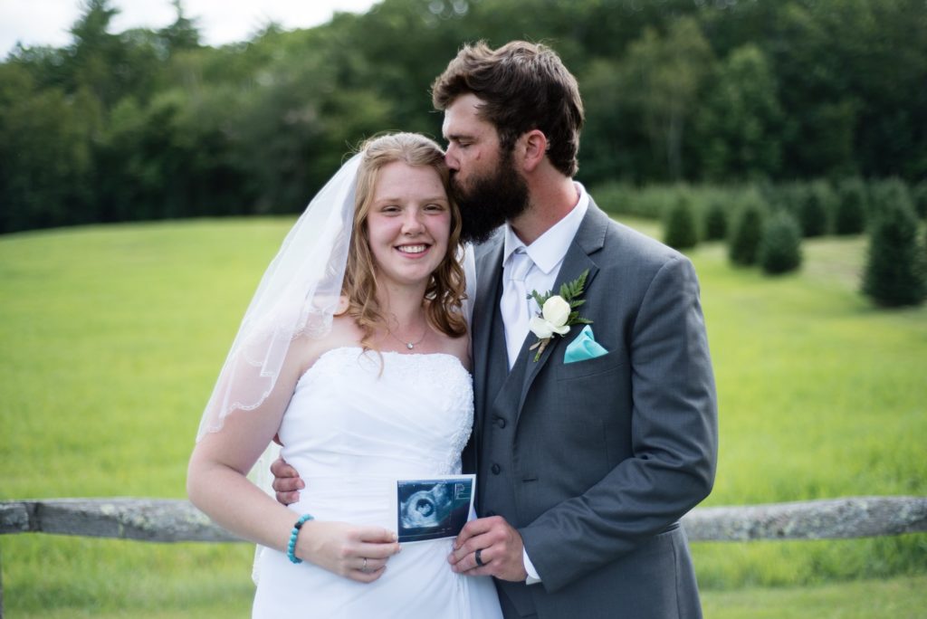Bride and groom wedding day pregnancy announcement