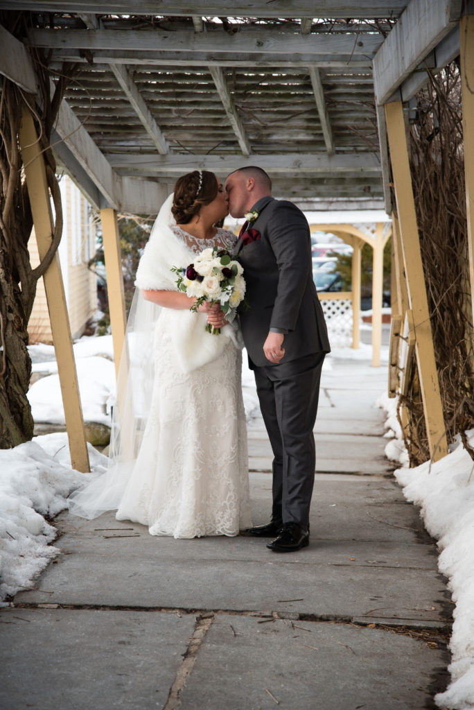 Bride and groom kissing on walkway