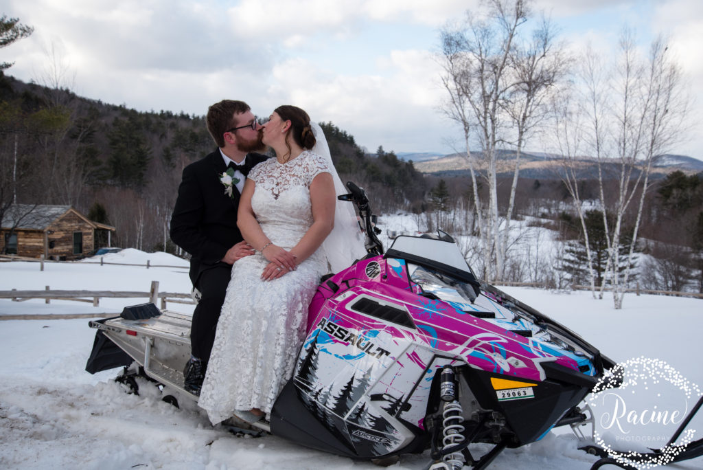 Bride and groom kissing on snowmobile