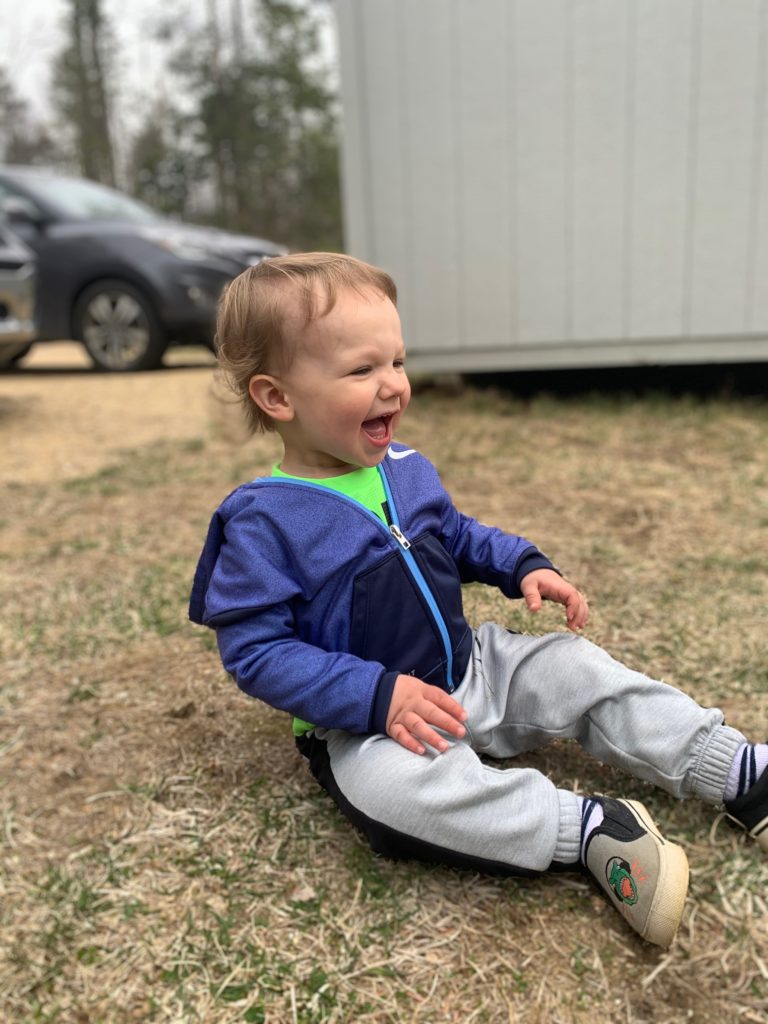toddler boy laughing outside