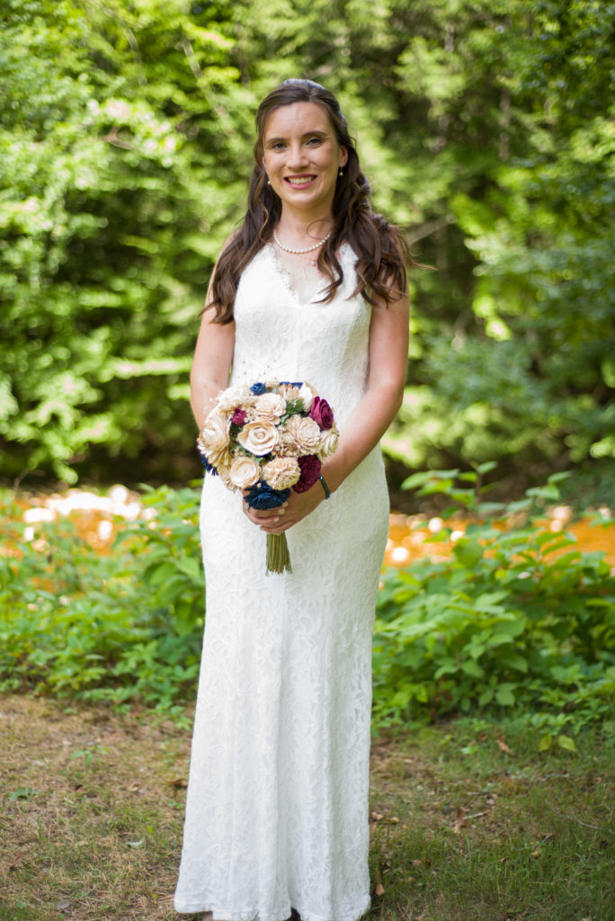 Bride in front of the cascades holding bouquet