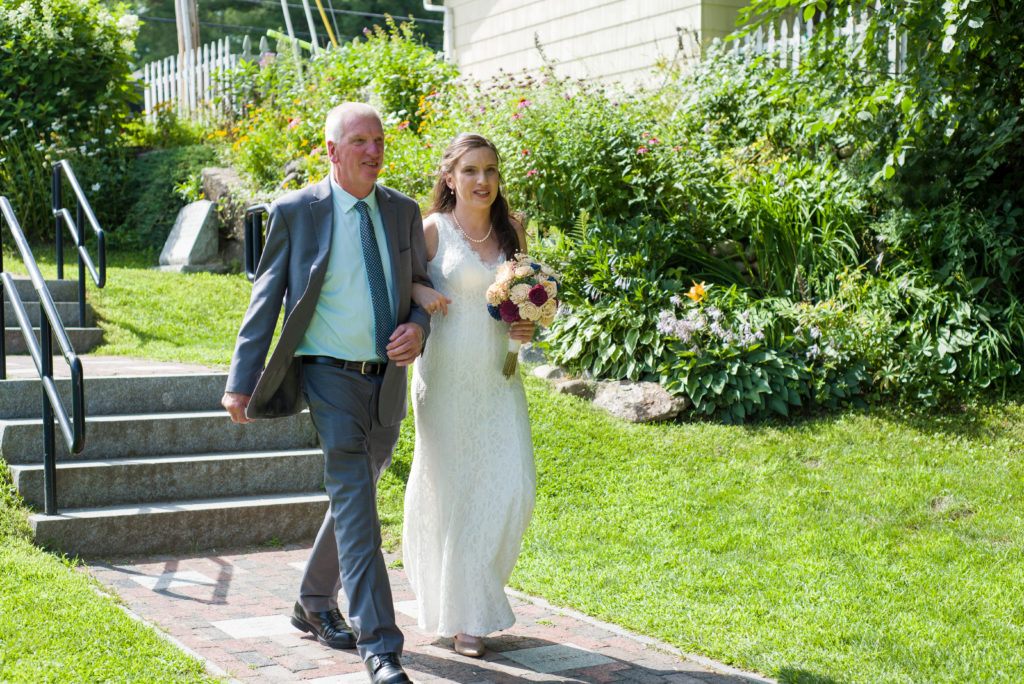 bride walking down aisle with her father at Cascade park across the street from Woodstock Inn Brewery