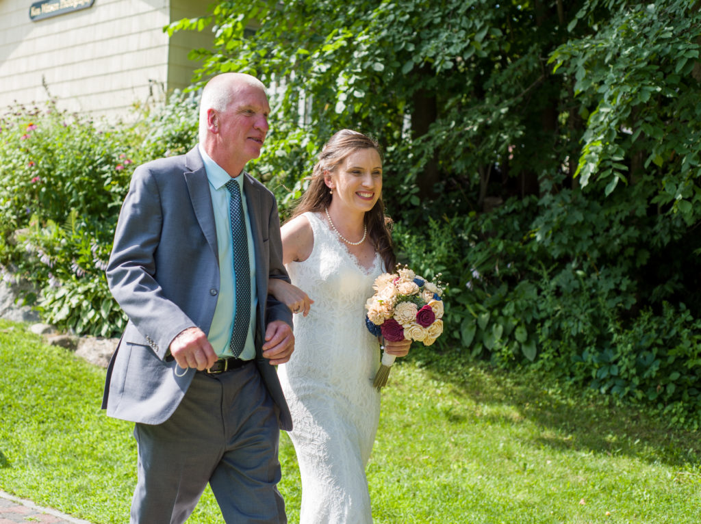 bride walking down aisle with her father at Cascade Park across the street from Woodstock Inn Brewery