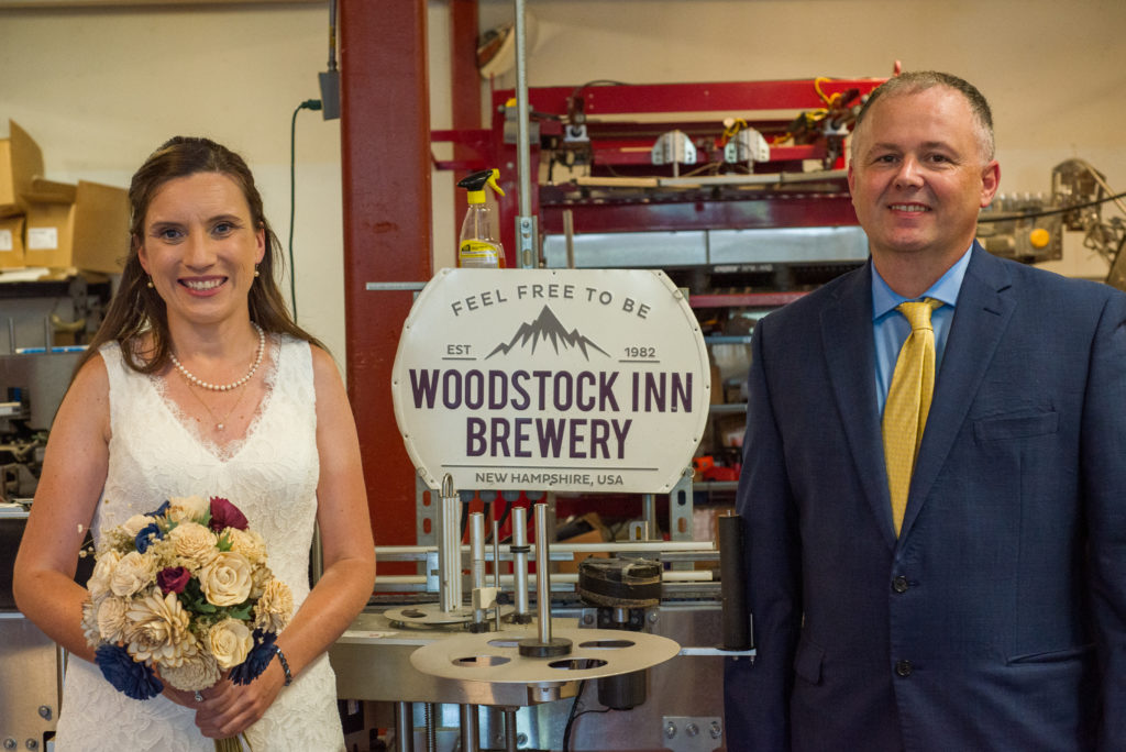 Bride and groom in front of the woodstock inn brewery sign in brewery
