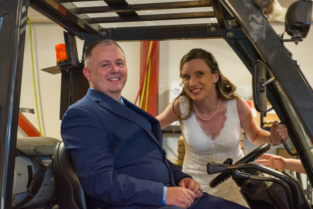 bride and groom sitting on the forklift at the woodstock inn brewery