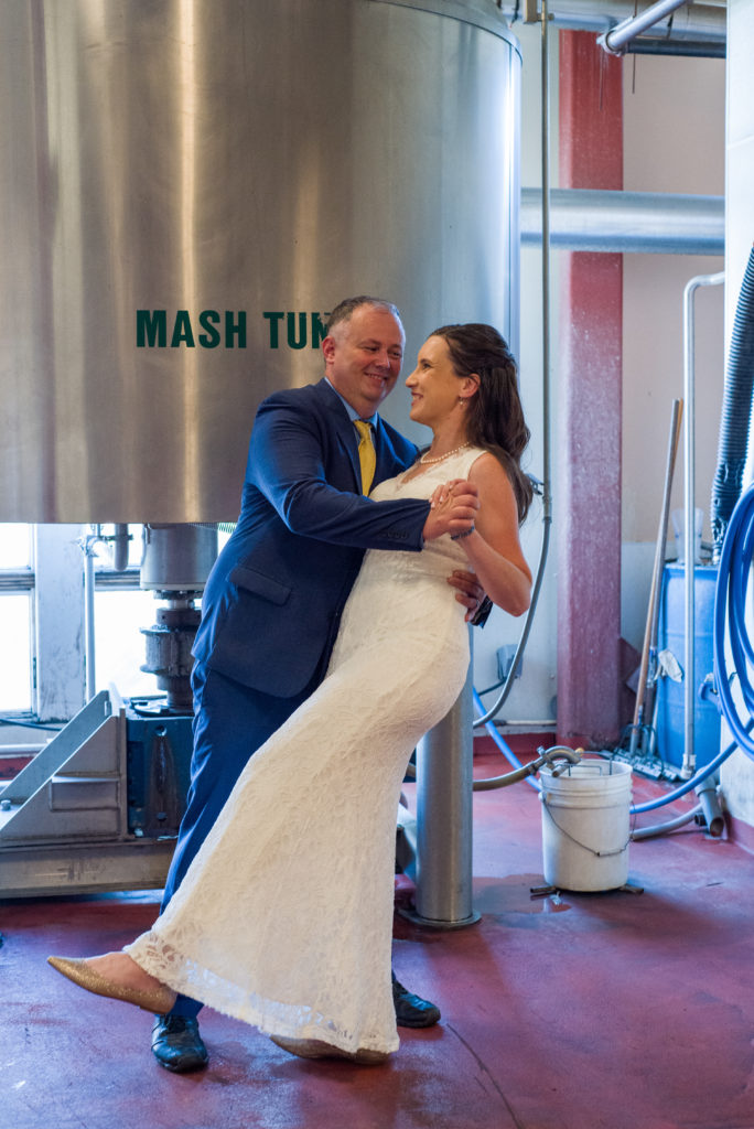 bride and groom dipping in front of the mash tunnel at the woodstock inn brewery