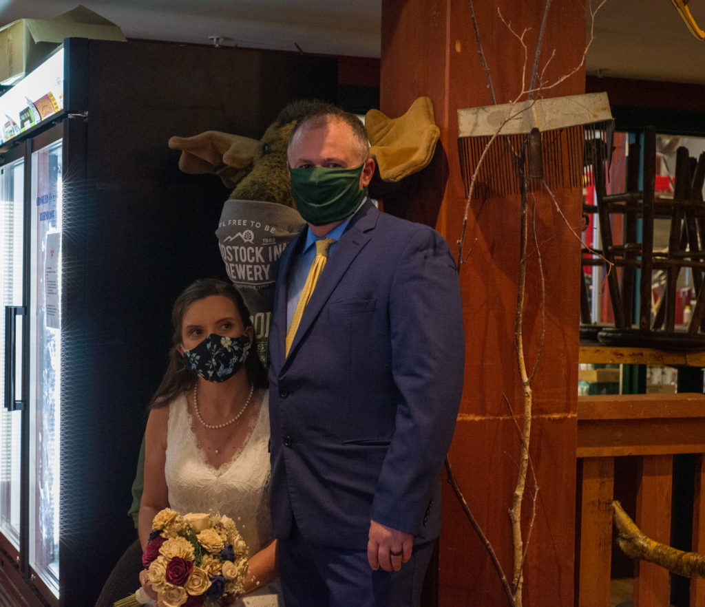bride and groom wearing masks with a stuffed animal moose who is also wearing a mask at the Woodstock Inn Brewery