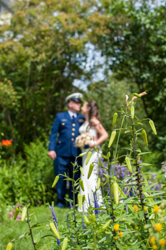 bride and groom kissing not in focus, flowers in focus