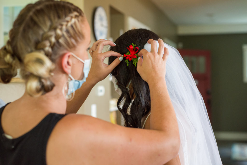hair and make up artist fixing bride's hair