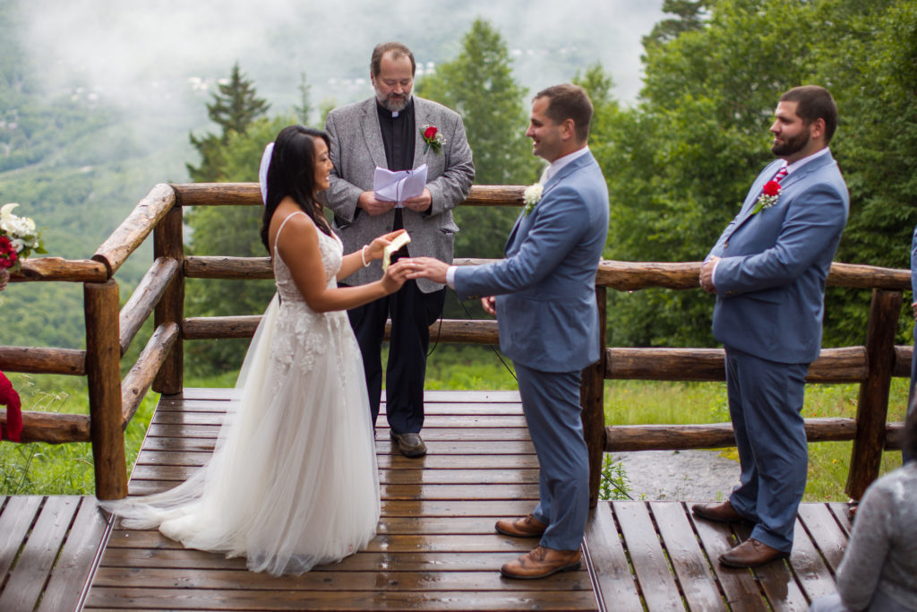 bride putting the ring on groom's finger while sharing her vows