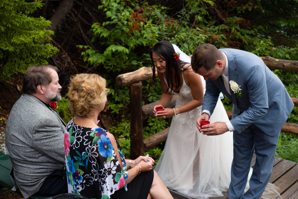 bride and groom bowing during tea ceremony at mountain top ceremony