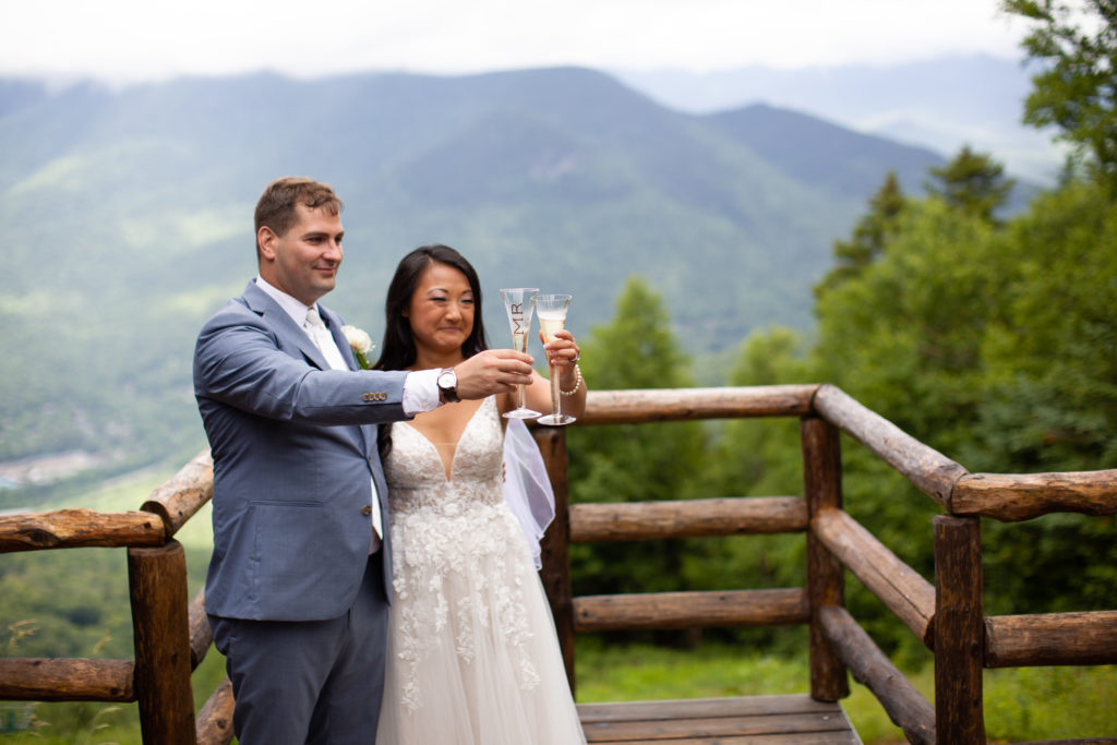 bride and groom toasting champagne at mountain top wedding