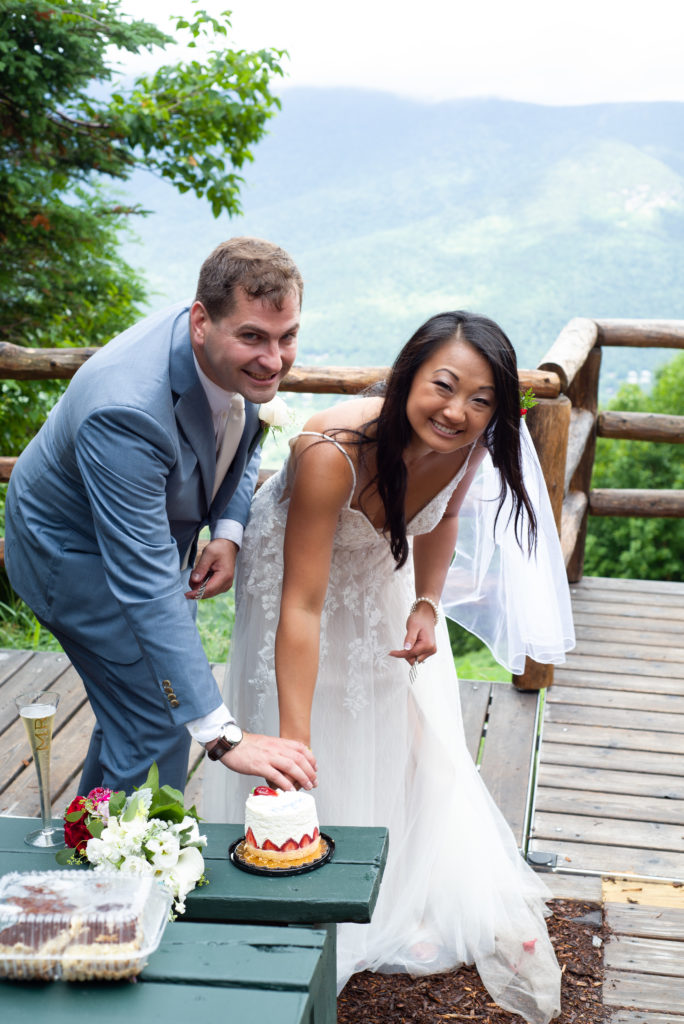 bride and groom cutting the cake at mountain top ceremony