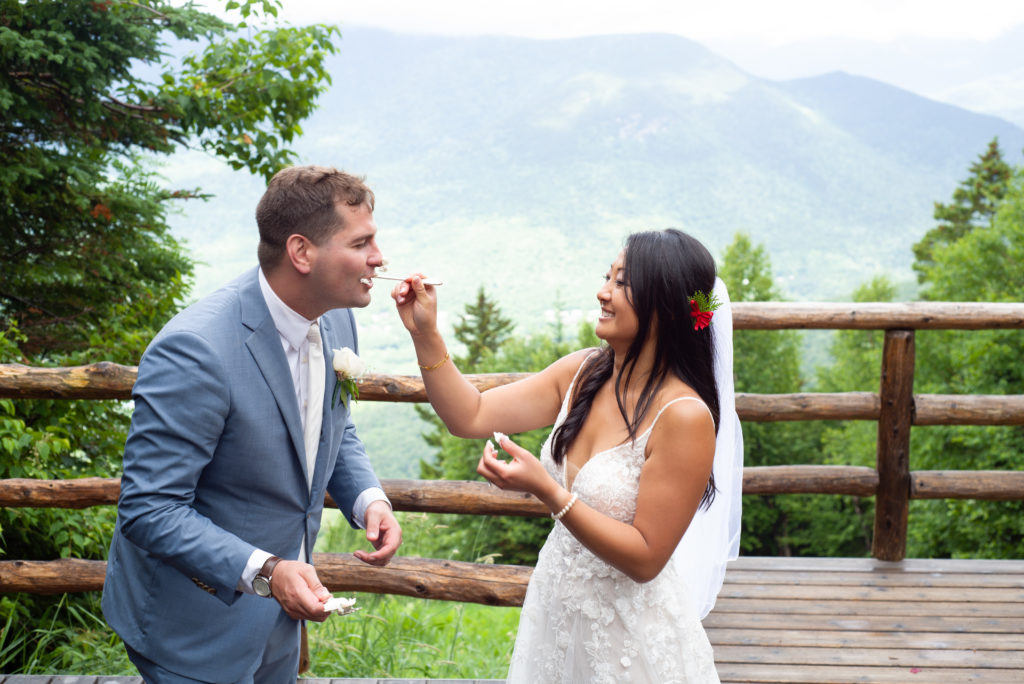 bride feeding groom cake at mountain top wedding