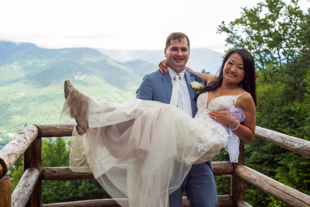 groom holding bride at mountain top wedding
