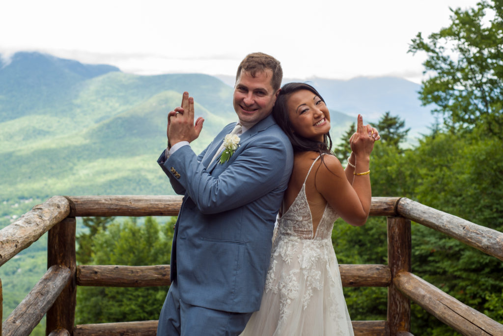 bride and groom back to back with their hands like guns at mountain top wedding