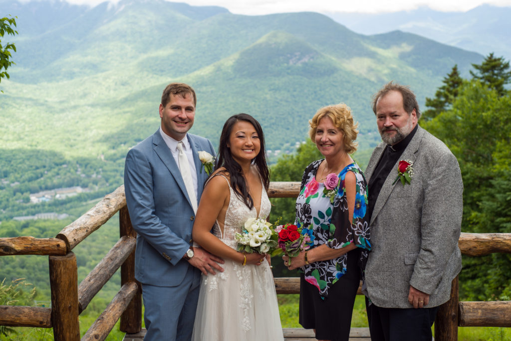 bride and groom with groom's parents at mountain top wedding