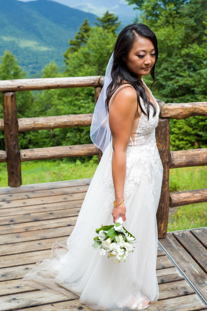bride glancing down at her bouquet at mountain top wedding