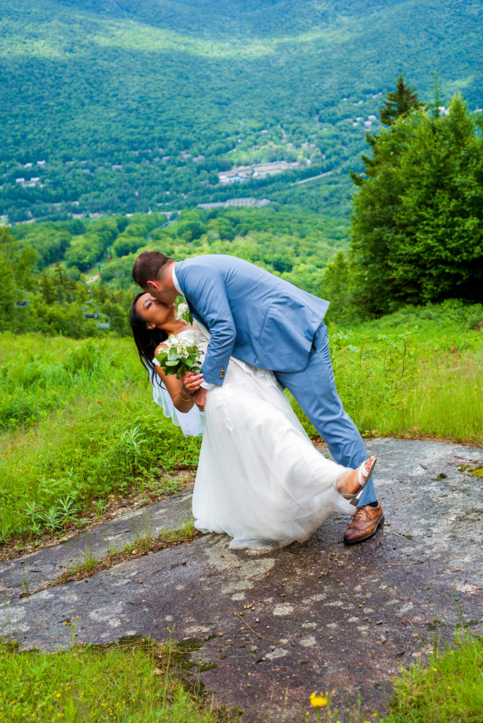 groom dipping bride and kissing in the mountain valley