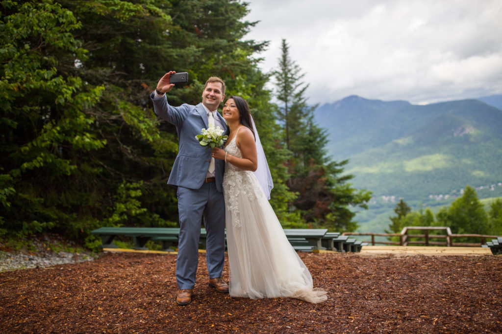 bride and groom taking a selfie at mountain top wedding