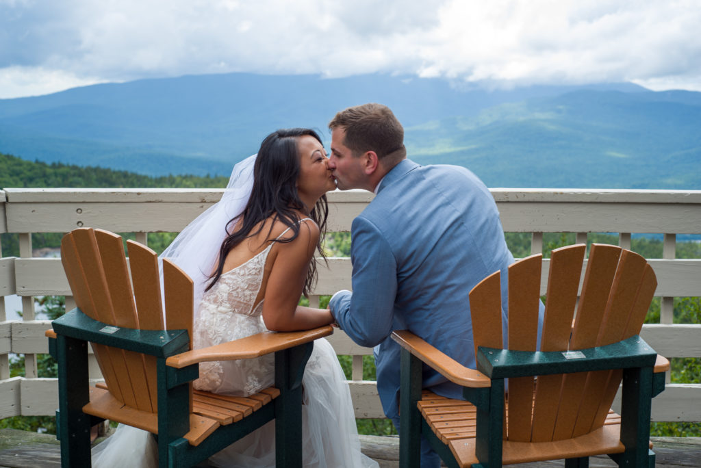 bride and groom kissing with mountains in the background
