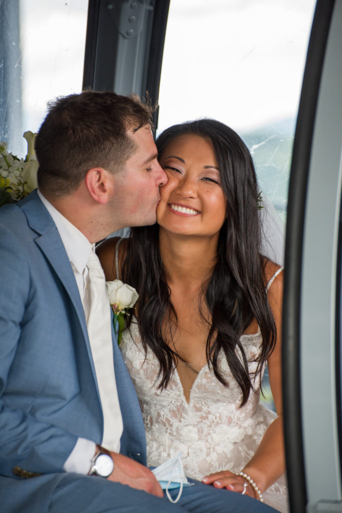 groom kissing bride on the cheek in the gondola