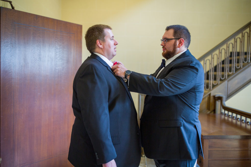 groom having his tie fixed by best man