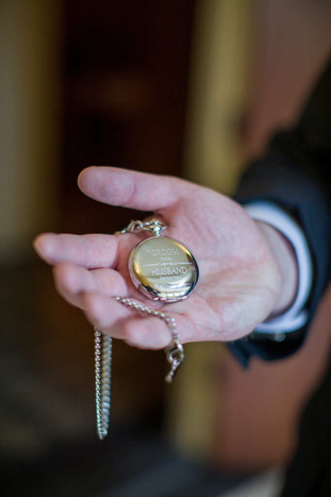 groom showing off his new pocket watch
