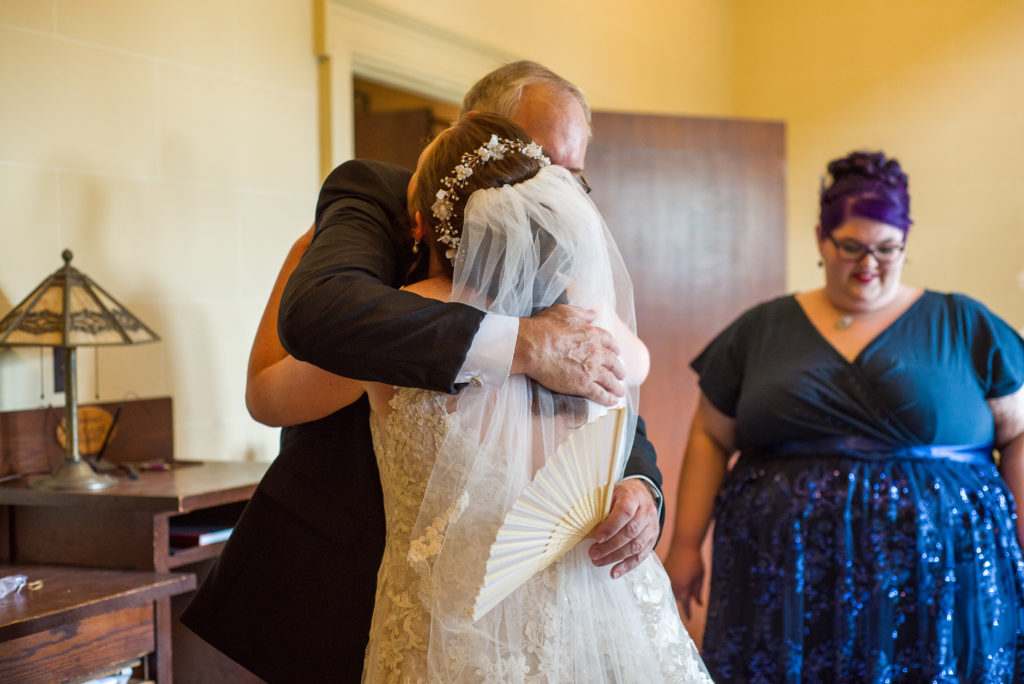 father of the groom hugging bride for the first time