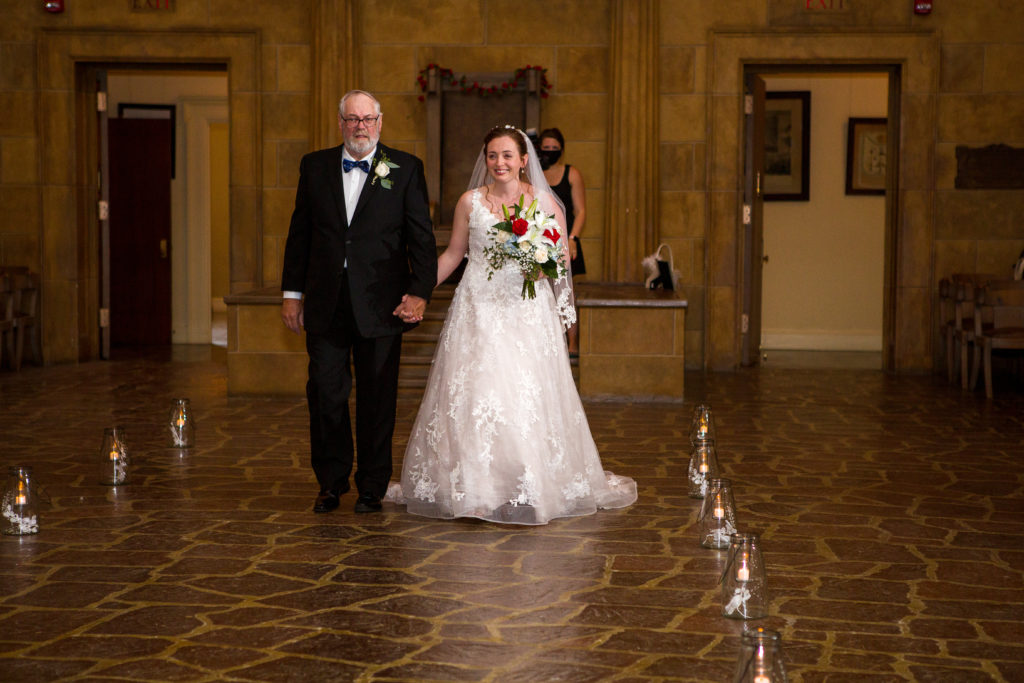 Bride and her father walking down the aisle in masonic temple