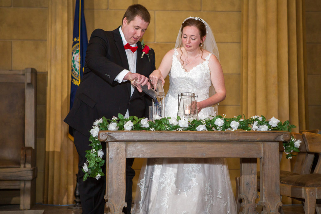 Bride and groom mixing glass beads together during the ceremony in masonic temple