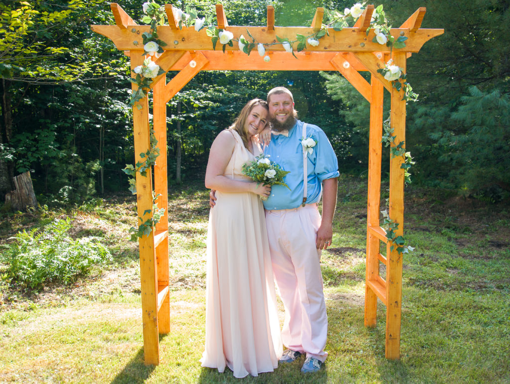 bride and groom under ceremony arbor